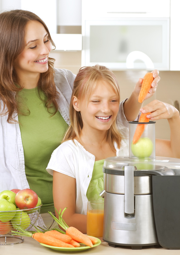 Happy Family making fresh apple and carrot juice